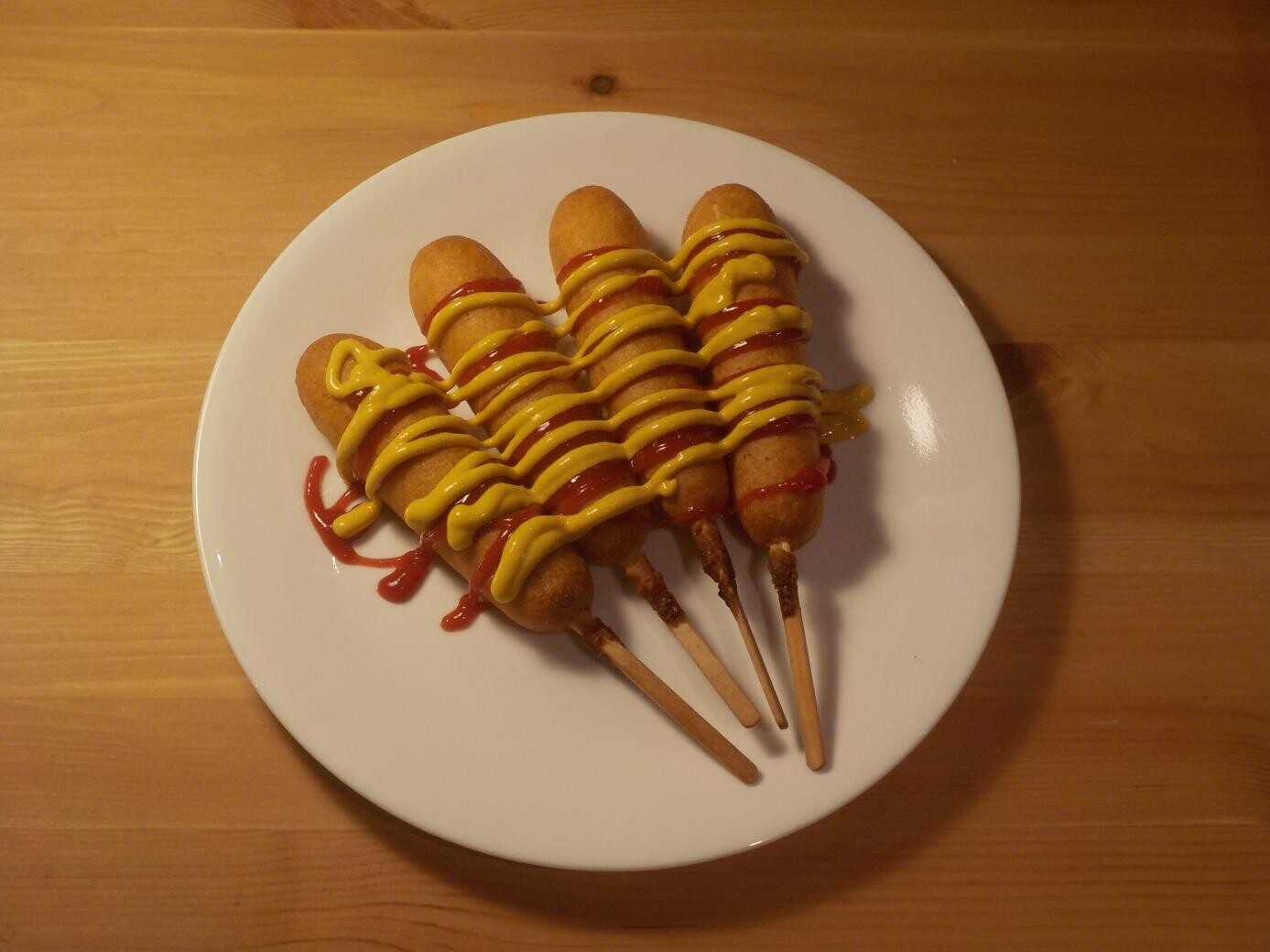 four corn dogs on a plate